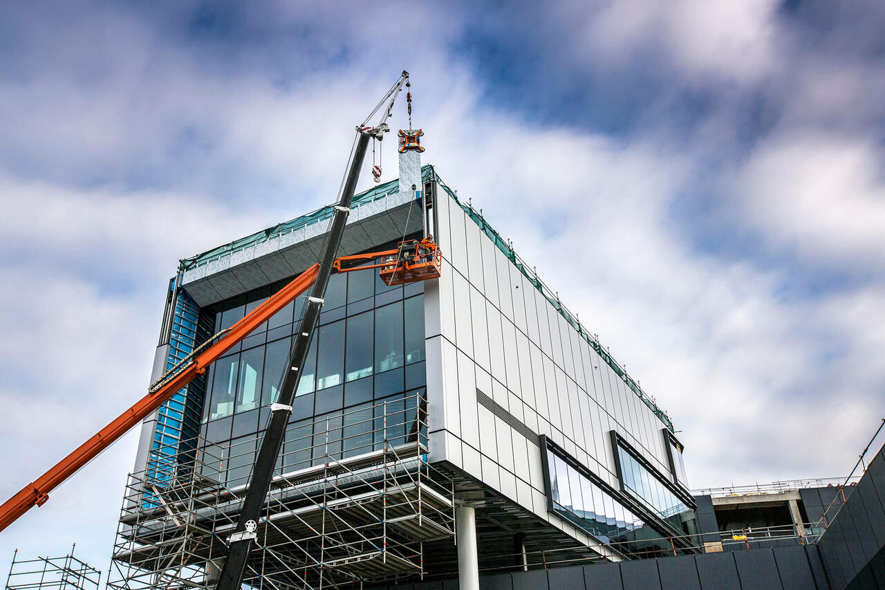 Crane and boom lift installing cladding on the entry cloister of the New Royal Adelaide Hospital